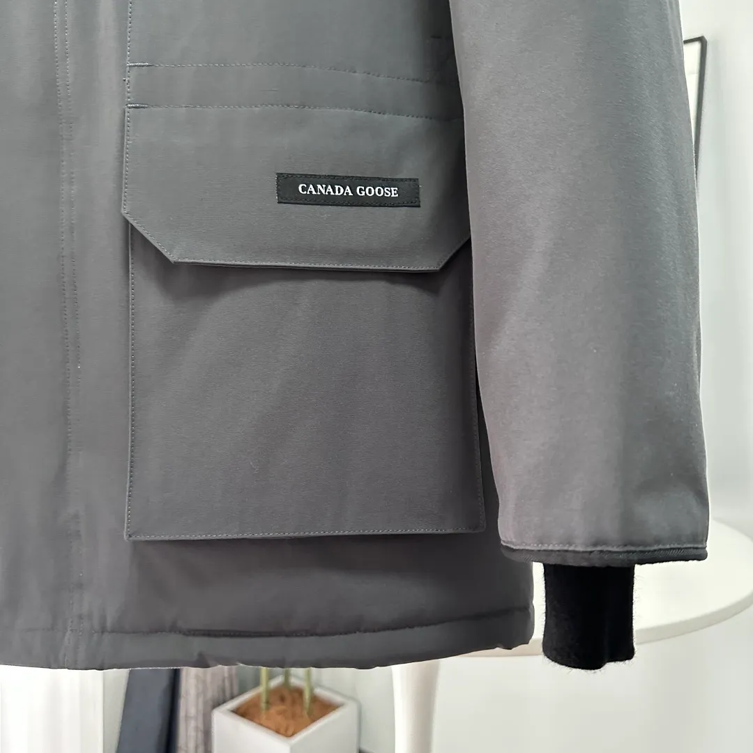 P700 CANADA GOOSE｜Canada Goose Expedition Parka｜Classic upgrade New 08 style Color: graphite gray, off-white, black, pink, navy blue, sky blue, Size: XS, S, M, L, XL, XXL, Product introduction Loose fit, multi-pocket design Larger size for free movement. 6 exterior pockets: 4 reversible front pockets, zippered side entry. There is a practical pocket on the left sleeve and a top pocket on the right sleeve. There is a drawstring on the inside of the waist and a logo patch on the back. The waist is designed with an inside drawstring, which can be adjusted to provide excellent warmth. Woven grab straps at upper back with “Expedition” logo patch • Hood with removable zipper trim, interchangeable hood trim for personalization and added protection (this jacket is not available with the classic hood trim) • Chin protection element has a tricot inner fabric for softness and comfort • Woven grab straps at upper back with “Expedition” logo patch • Internal drawstring at the waist, adjustable to provide excellent warmth •Snap-in rib knit cuffs for added comfort and optimal heat locking in •Stylish hanging inner straps allow the jacket to be carried over the shoulder, hands-free •Stowaway nylon stretch snow skirt for added protection •Two-way zipper covered fly with Velcro® snaps that unzips from the bottom for increased range of motion and breathability. A windproof fly is designed under the zipper for an extra layer of protection. • 6 exterior pockets: 4 two-way pockets on the front with top flap and Velcro® snaps, and zippered side entry. Utility pockets on left sleeve and right sleeve with top flap and velcro® snaps Internal pockets: 1 zipped pocket, 2 mesh drop-in pockets Embroidered Canada Goose logo